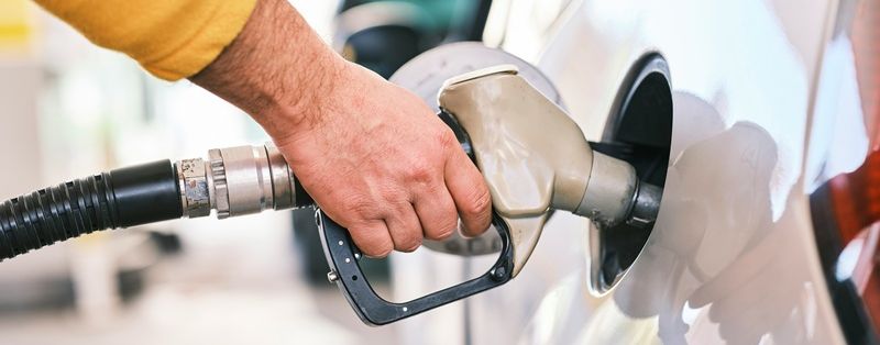 Мужчина заправляет бак автомобиля, и все документы в порядке.